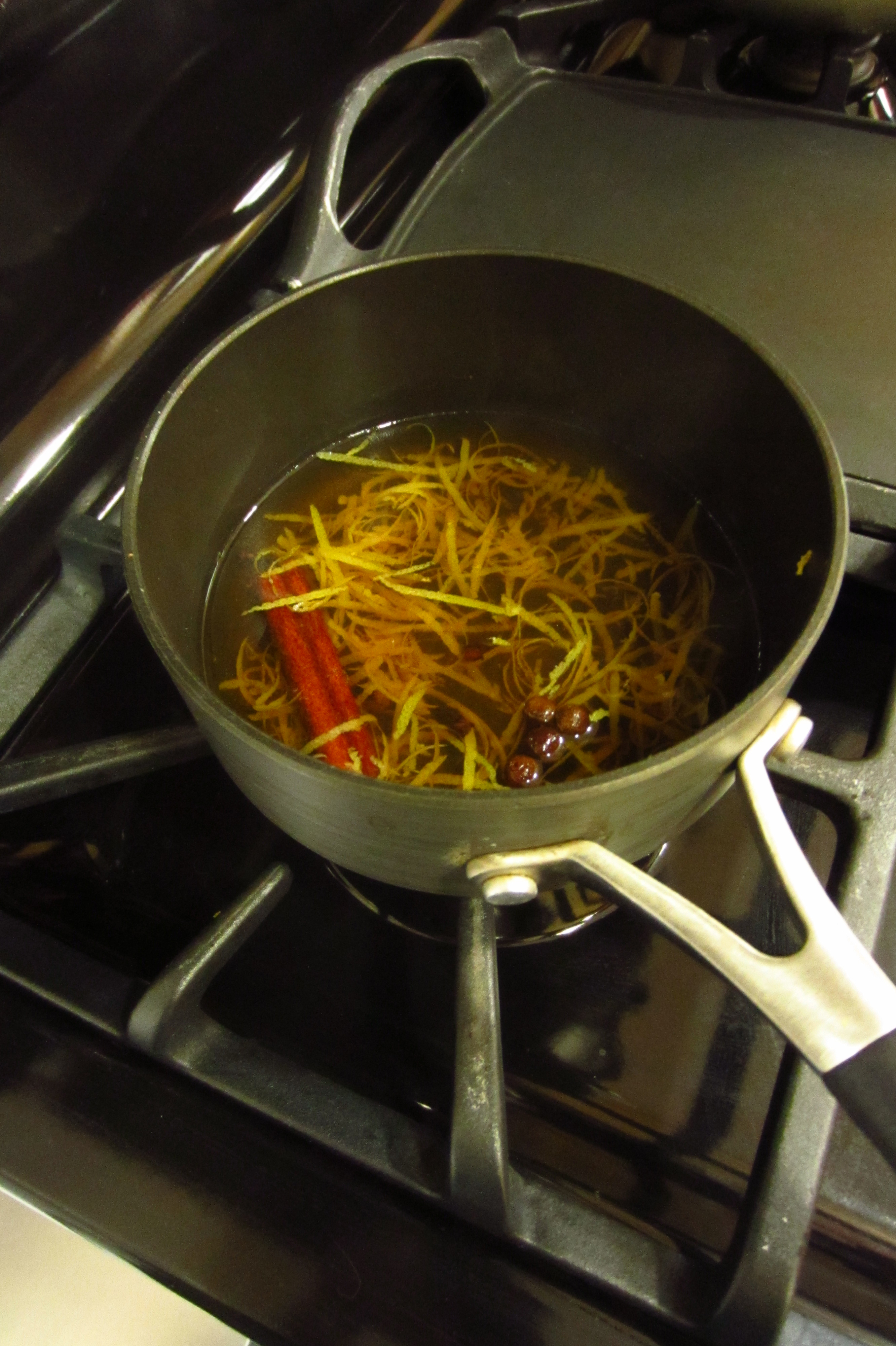 heating zest and spices in bourbon